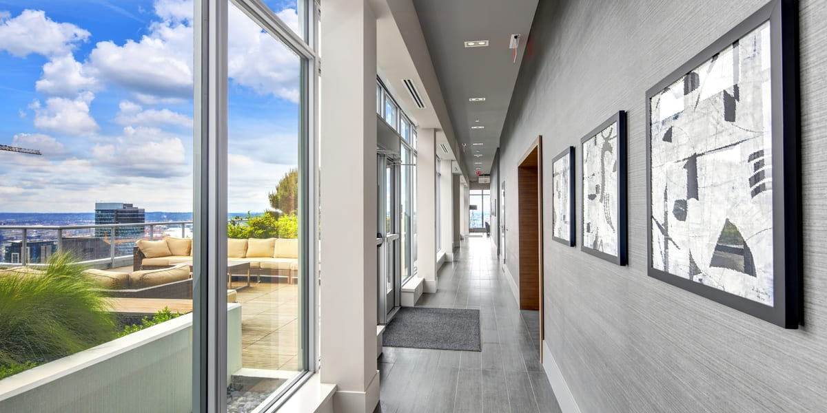 Hallway view of apartment in Seattle on sunny day with view of city through window