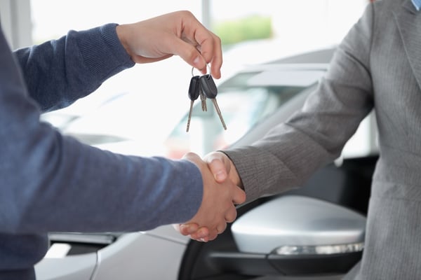 People shaking each other hands while holding keys