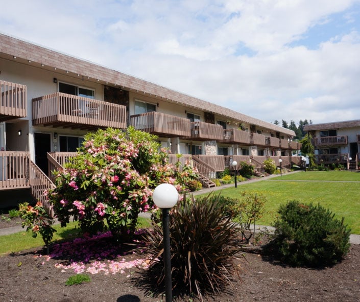 Two-story apartment building with balconies and landscaped courtyard in Des Moines, WA