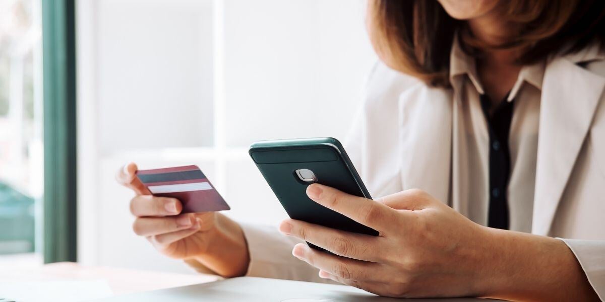 Woman Holding Credit Card and Using Phone Online Shopping