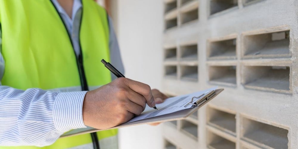inspector or engineer is inspecting construction house using a checklist. Engineers and architects or contactor count materials for construction